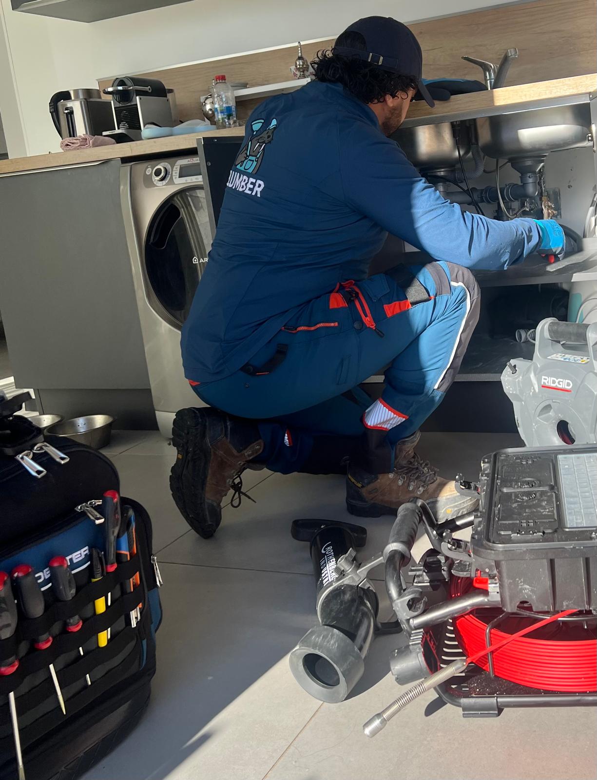 Technicien Plumber Deboucheur débouchant une évacuation sous évier